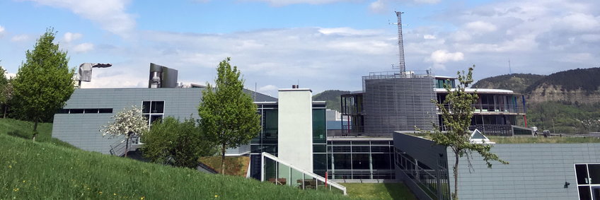 Blick aufs Max-Planck-Institut für Biogeochemie von der Westseite, sozusagen die Rückansicht. In der Mitte ist der  Wetterstationsmast, an dem oft Sensoren angebracht sind für Test uns Vergleichsmessungen. Im Hintergrund die Kernberge.