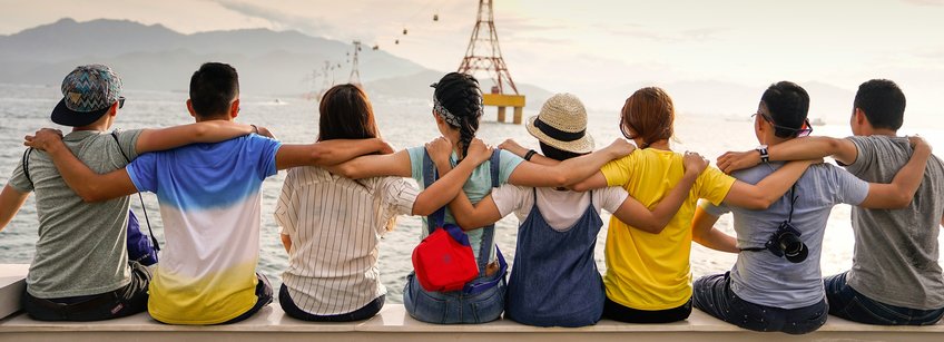 Cooperation, social responsibility, tolerance and team work is essential in successful science. (Photo by Duy Pham via unsplash) A group of people sitting together and holding each other at the shoulders.