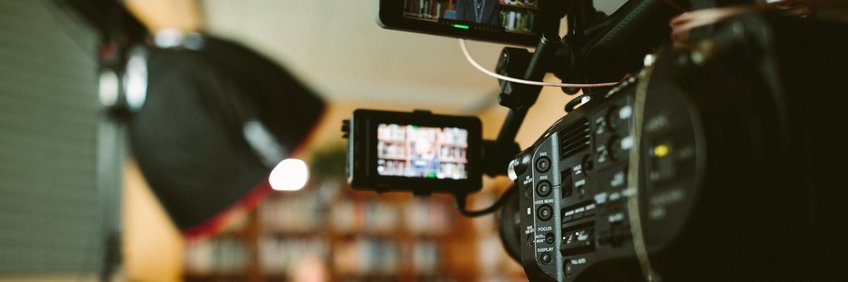 Filmaufnahme eines Interviews in einer Bibliothek (©Sam McGhee on Unsplash) Filmaufnahme eines Interviews in einer Bibliothek.