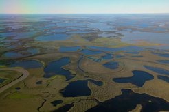 Das Mackenzie River Delta ist ein Mosaik aus Seen, Flüssen und Bächen in einer flachen Landschaft mit kaum und ausschließlich niedriger Vegetation.