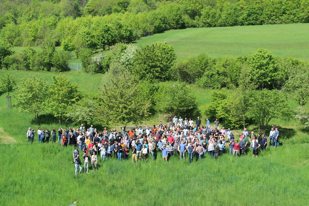 Lage group of pople in a meadow.